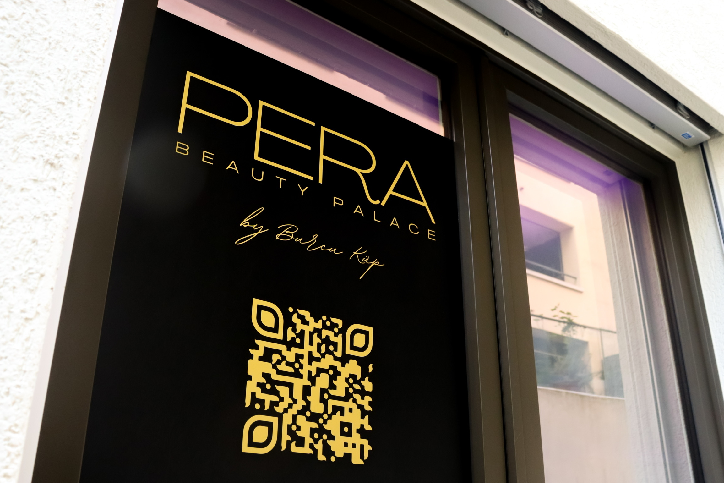 Willkommen im PERA Beauty Palace! Unser Eingangsbereich und die Innenwand sind stolz mit unserem Logo geschmückt und laden Sie ein, eine Welt der Schönheit und Entspannung zu entdecken. Betreten Sie unser stilvolles Kosmetikstudio durch die einladende Tür und lassen Sie sich von der Ästhetik unserer mit dem Logo verzierten Innenwand verzaubern. Bei PERA Beauty Palace erleben Sie exzellenten Service, erstklassige Behandlungen und eine herzliche Atmosphäre. Tauchen Sie ein in die Welt der Schönheit und gönnen Sie sich das Verwöhnerlebnis, das Sie verdienen. Wir freuen uns darauf, Sie bei uns willkommen zu heissen!